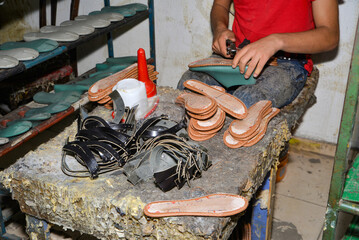 The shoemaker is making shoes in the workshop.
