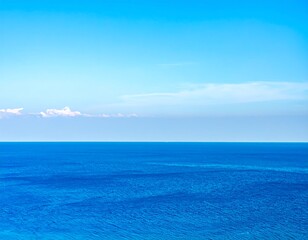 Obraz premium Wide expanse of deep blue ocean meeting a clear, pale blue sky