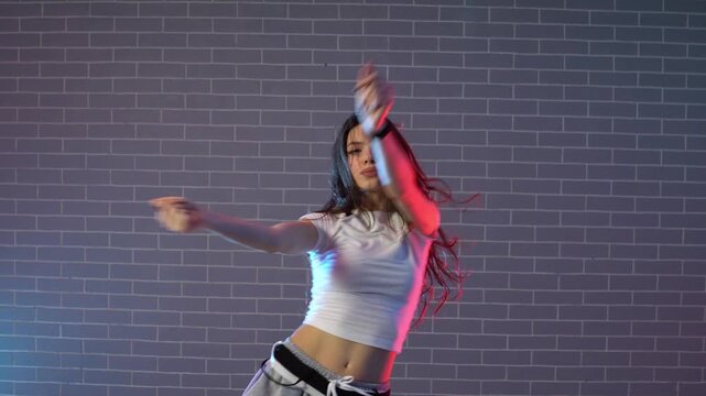 young girl choreographer dancing hip hop in neon lighting, woman performing on camera in and practicing dance jazz funk in dark studio
