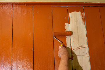 Roller painting of a wooden floor, background with paint on a wooden floor. Summer house renovation...