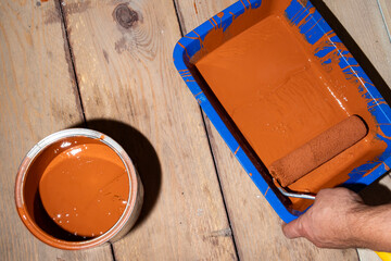 Roller painting of a wooden floor, background with paint on a wooden floor. Summer house renovation...