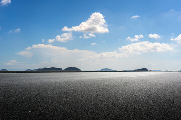 Expansive Open Road Surrounded by Serene Landscape and Blue Skies