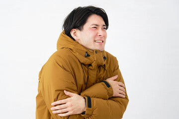 ダウンジャケットを着た男性　寒気　白背景