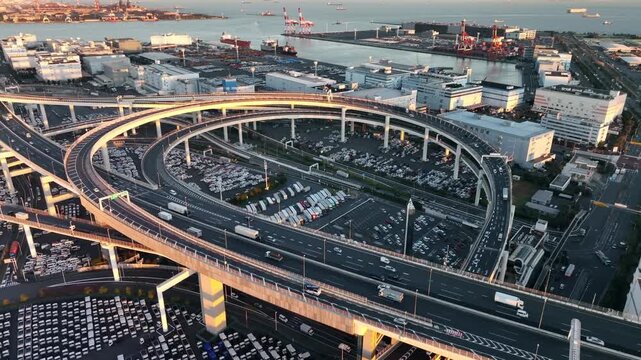 高速道路、ジャンクション、ドローン、空撮、自動車、交通、モビリティ、都市、社会、物流、運送業、インフラ、建設、俯瞰、展望、パノラマ、ハイアングル、鳥瞰図、風景、景観、景色、上から見た、見下ろす、現代、都会、倉庫、工場、トラック、駐車場、インターチェンジ、パーキングエリア、サービスエリア、ビル、埠頭、産業、工業、センター、湾岸、港湾、日本、カーブ、高架、道路、設計、ビジネス、夕焼け、夜明け、夕方、夕
