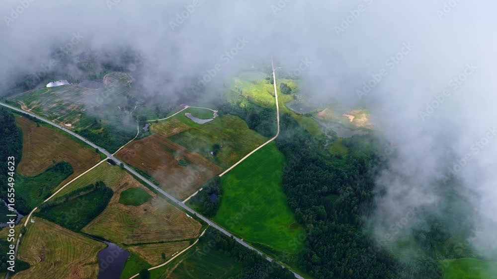 Poster top drone shot of partial view of agriculture fields by clouds in a countryside.