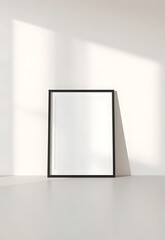 Clean Mockup of a Black Frame on a White Wall with Sunlight, Ideal for Art Showcase and Interior Design Presentation