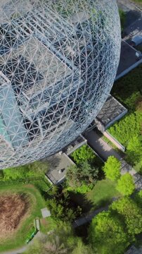 Aerial view of Parc Jean-Drapeau in Montreal, Canada, featuring the Biosphere, lush greenery, and the Jacques Cartier Bridge in the background. A popular tourist destination.