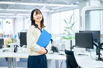 オフィスでファイルを持つ女性　ビジネスウーマン　派遣社員