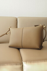Stylish brown handbag resting on a light sofa
