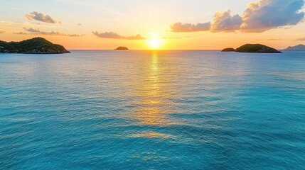 Naklejka premium Breathtaking sunset over calm ocean, framed by two islands, creating serene atmosphere