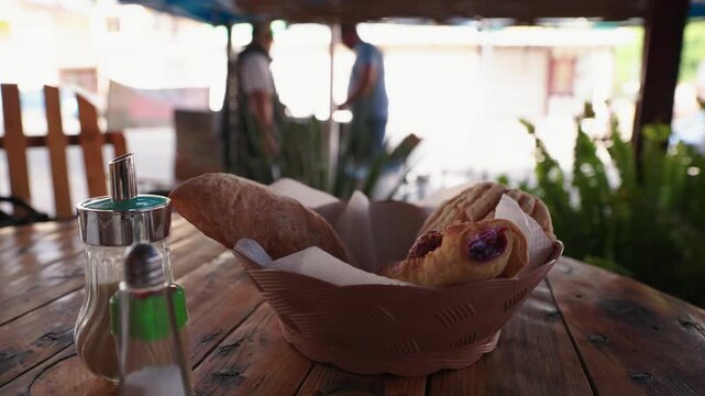 Fresh Bread Basket on a Rustic Table with Background Interaction