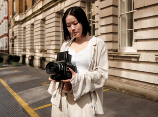 Young photographer using medium format camera in urban setting