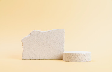 Empty stone podium against a beige wall background, ideal for mockups and showcasing cosmetic products.