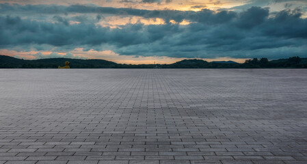 Expansive Paved Surface Under Dynamic Cloudy Sky at Dusk