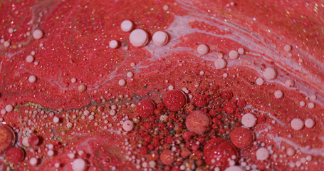 Oil fluid. Paint art. Blur red pink white color flowing wet stains golden droplets liquid...