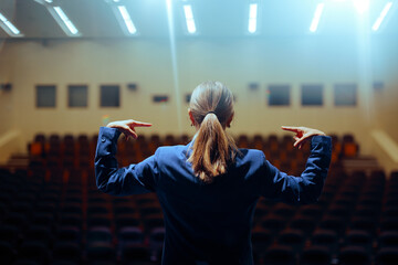 Arrogant Leader Rehearsing a Public Speech Pointing to Herself. Narcissistic politician getting ready to deliver her message on stage 
