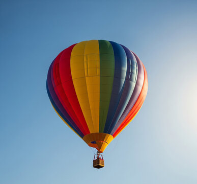 Colorful Rainbow Hot Air Balloon Flying in Clear Blue Sky Travel Adventure