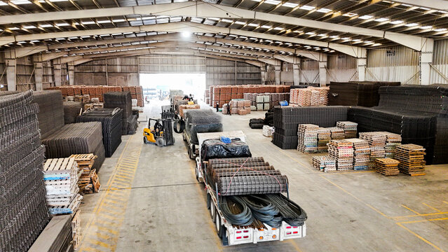 Interior de bodega industrial con materiales y camiones