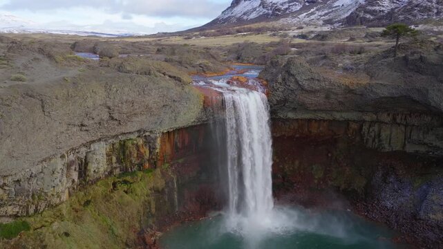 Salto del Agrio near Caviahue, Neuqu&eacute;n, shows a powerful waterfall surging over columnar basalt into a teal pool, hurling spray and mist as a river thunders through the volcanic canyon, Drone orbiting