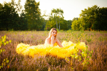 A stunningly beautiful woman clad in a vibrant and bright yellow dress, completely surrounded by...
