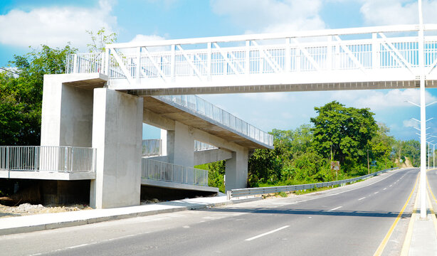 Puente peatonal sobre carretera en zona rural
Vista a&eacute;rea de carretera con puente para peatones