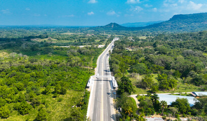 Puente peatonal sobre carretera en zona rural
Vista aérea de carretera con puente para peatones