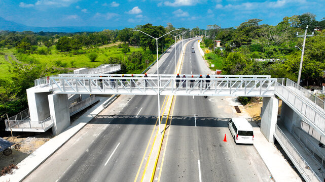 Puente peatonal sobre carretera en zona rural
Vista a&eacute;rea de carretera con puente para peatones
