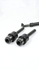 Two black cylindrical metal tools with threaded ends, possibly drill bits or chucks, lie on a white background