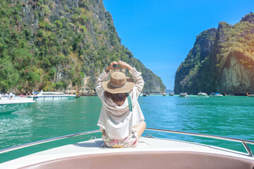 Woman tourist on boat trip, happy traveller relaxing at Pileh lagoon on Phi Phi island, Krabi,...