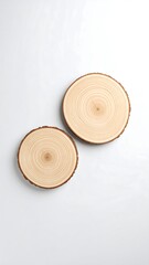 Two light beige wooden discs on a light gray surface
