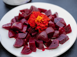 Rich red beet salad displayed artistically with a flower decoration.