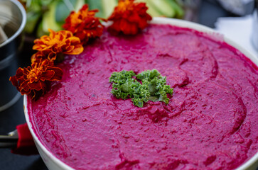 Rich Beetroot Hummus Artfully Presented with Herbs and Flowers