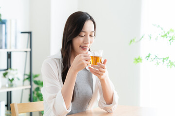 紅茶を飲んでリビングでくつろぐ若い女性