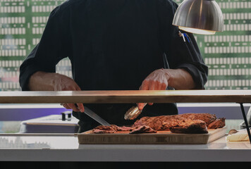 Chef Carving Juicy Roast Meat in a Bright, Modern Kitchen Environment