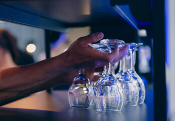 Hands Placing Stacked Clear Glasses on Shelf with Modern Design