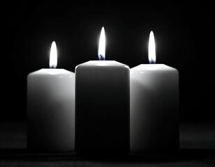 Three white candles in dark background
