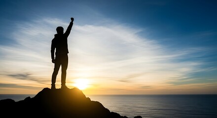 Man celebrating success on mountain peak at sunrise over the ocean