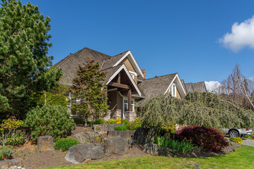 Two story stucco luxury house with nice spring blossom landscape in Vancouver, Canada, North America. Day time on May 2025.