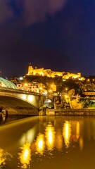 Fototapeta premium Night cityscape with bridge and castle reflection