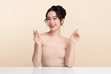 A beautiful young Asian woman with clean, fresh skin against a beige background. Skincare, facial...