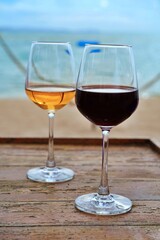 Red and rosé wine glasses by the beach on a sunny day