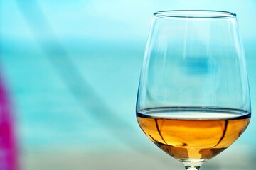 Rosé wine glass with golden sea reflection inside the wine