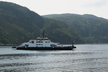 Ferry navigating calm waters surrounded by lush green mountainous landscape.