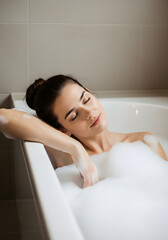 Obraz premium Relaxing in a bubble bath ultimate spa day self care woman serene peaceful calm tranquility beauty wellness bath time foam bubbles luxury bathroom