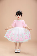 An Asian little girl in a pink dress