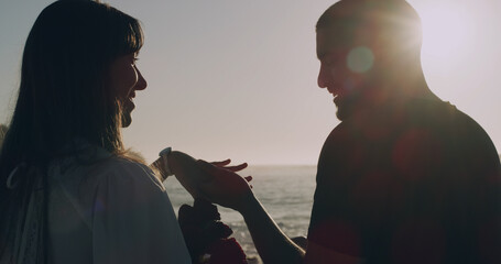 Love, holding hands and holiday with couple at beach for travel, summer and flowers. Sunset,...