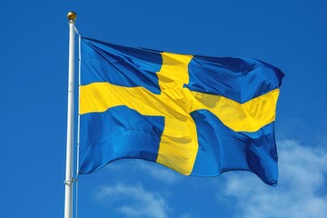 A vibrant Swedish flag flutters in the wind under a clear blue sky, showcasing its bold blue color and distinctive yellow cross during a sunny day in Sweden.