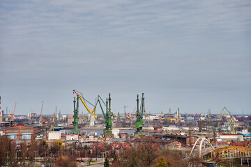 Fototapeta premium Panoramic view of shipyard with port cranes, industrial buildings and harbor infrastructure