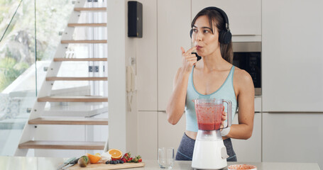 Headphones, smoothie and thinking with a woman for healthy diet, nutrition and fruit in kitchen. Taste, blender and female person with vegan ingredients for drink, shake or streaming music in home
