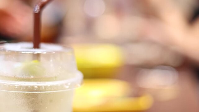 Hand Reaching for Iced Drink in Busy Caf&Atilde;&copy; Setting